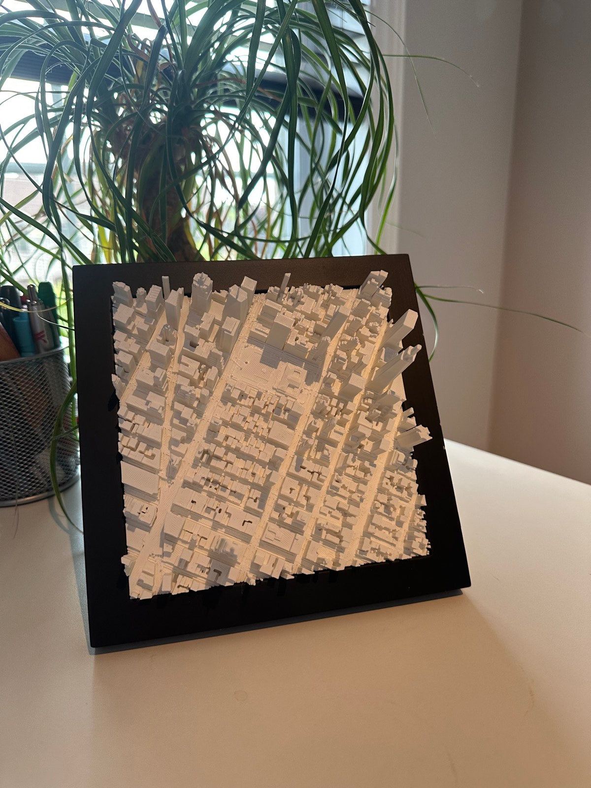 A framed Mini City Prints cityscape on a real wall